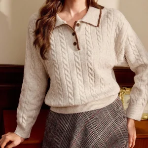 Pull en maille torsadée à col polo bicolore abricot pour femme, orné de détails à épaules tombantes.