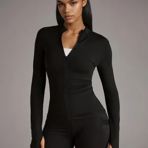 Veste zippée matelassée ajustée à col montant pour la course et l'exercice, en noir.